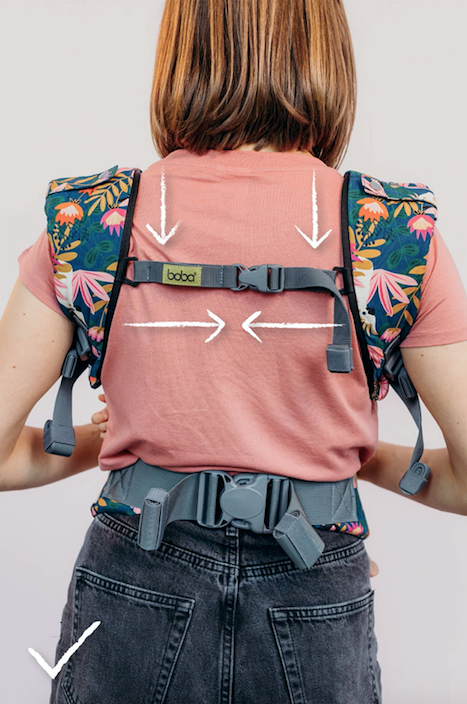 Back view of a woman wearing the boba x baby carrier back strap correctly.